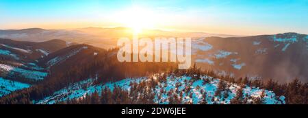 Vue panoramique sur les montagnes Eagle et Jesenik depuis le sommet de Kralicky Sneznik en hiver au coucher du soleil. La neige est couchée sur des collines avec beaucoup d'arbres. Banque D'Images