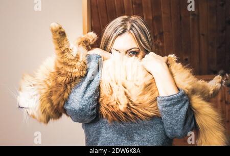 Une femme portant un chat au gingembre moelleux Banque D'Images