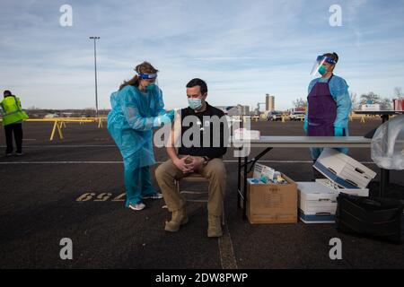 Manhattan, Kansas, États-Unis. 22 décembre 2020. Le superviseur de la clinique du département de la santé du comté de Riley, ARYN PRICE, à gauche, administre la première dose du vaccin Moderna au directeur adjoint du SGE du comté de Riley, JOSH GERING. Le vaccin Moderna est arrivé mardi dans le comté de Riley et 150 des 200 doses seront administrées à l'avance aux travailleurs de la santé de première ligne. Une deuxième série de doses devrait arriver dans la semaine à deux semaines. Crédit: Luke Townsend/ZUMA Wire/Alay Live News Banque D'Images