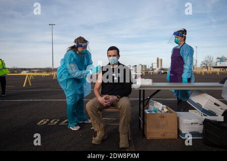 Manhattan, Kansas, États-Unis. 22 décembre 2020. Le superviseur de la clinique du département de la santé du comté de Riley, ARYN PRICE, à gauche, administre la première dose du vaccin Moderna au directeur adjoint du SGE du comté de Riley, JOSH GERING. Le vaccin Moderna est arrivé mardi dans le comté de Riley et 150 des 200 doses seront administrées à l'avance aux travailleurs de la santé de première ligne. Une deuxième série de doses devrait arriver dans la semaine à deux semaines. Crédit: Luke Townsend/ZUMA Wire/Alay Live News Banque D'Images