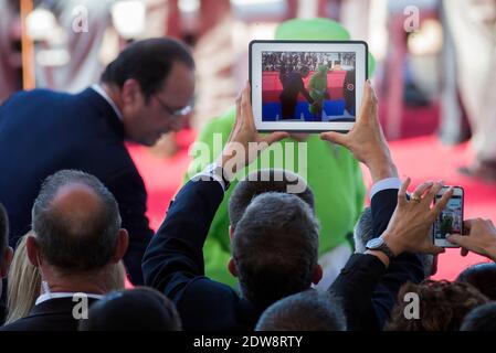 La reine Elizabeth II de Grande-Bretagne est vue sur un écran d'iPad tandis qu'elle arrive flanquée par le président français François Hollande (L) lors d'une cérémonie internationale marquant le 70e anniversaire des débarquements alliés le jour J sur Sword Beach à Ouistreham, en Normandie, France, le 06 juin 2014. Plus de 75,000 soldats britanniques canadiens et autres du Commonwealth ont débarqué sur les plages de Normandie le 06 juin 1944, aux côtés des États-Unis et des Français libres, dans le cadre d'une invasion alliée de plus de 130,000 hommes. 7,900 autres troupes britanniques ont été débarquées par Air.l'invasion a établi un second front crucial dans la libération de l'E Banque D'Images