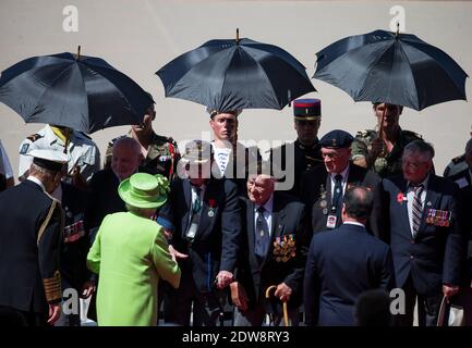 La reine Elizabeth II (C) de Grande-Bretagne salue les anciens combattants de la Seconde Guerre mondiale lors d'une cérémonie internationale marquant le 70e anniversaire des débarquements alliés le jour J sur Sword Beach à Ouistreham, en Normandie, France, le 06 juin 2014. Plus de 75,000 soldats britanniques canadiens et autres du Commonwealth ont débarqué sur les plages de Normandie le 06 juin 1944, aux côtés des États-Unis et des Français libres, dans le cadre d'une invasion alliée de plus de 130,000 hommes. 7,900 autres troupes britanniques ont été débarquées par Air. L'invasion a établi un second front crucial dans la libération de l'Europe de l'occupation nazie, menant finalement à la victoire pour Banque D'Images