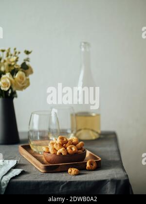 Taralli traditionnel italien ou taralini au vin blanc sur la table couvre la nappe en lin gris. Tarallini dans un petit bol en bois et vin rouge Banque D'Images