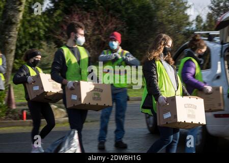 Seattle, Washington, États-Unis. 22 décembre 2020. Des bénévoles chargent des boîtes alimentaires d'urgence dans des véhicules en attente au North Seattle College de Seattle. Food Lifeline a parrainé la distribution communautaire en cours à mesure que le nombre de personnes en situation d'insécurité alimentaire dans l'État de Washington a doublé à la suite de la pandémie de Covid-19. Crédit : Paul Christian Gordon/Alay Live News Banque D'Images