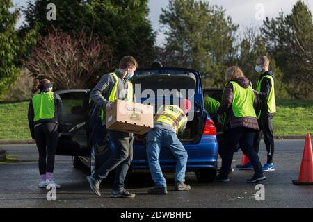 Seattle, Washington, États-Unis. 22 décembre 2020. Des bénévoles chargent des boîtes alimentaires d'urgence dans des véhicules en attente au North Seattle College de Seattle. Food Lifeline a parrainé la distribution communautaire en cours à mesure que le nombre de personnes en situation d'insécurité alimentaire dans l'État de Washington a doublé à la suite de la pandémie de Covid-19. Crédit : Paul Christian Gordon/Alay Live News Banque D'Images