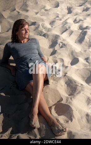 Femme assise dans les dunes Banque D'Images