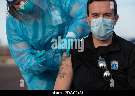 Manhattan, Kansas, États-Unis. 22 décembre 2020. Le superviseur de la clinique du département de la santé du comté de Riley, prix ARYN, administre la première dose du vaccin Moderna au directeur adjoint du SGE du comté de Riley, JOSH GERING. Le vaccin Moderna est arrivé mardi dans le comté de Riley et 150 des 200 doses seront administrées à l'avance aux travailleurs de la santé de première ligne. Une deuxième série de doses devrait arriver dans la semaine à deux semaines. Crédit: Luke Townsend/ZUMA Wire/Alay Live News Banque D'Images