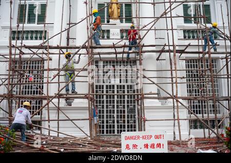 21.12.2020, Singapour, République de Singapour, Asie - après les travaux de rénovation, un groupe de travailleurs de la construction démonte un échafaudage en bois. Banque D'Images