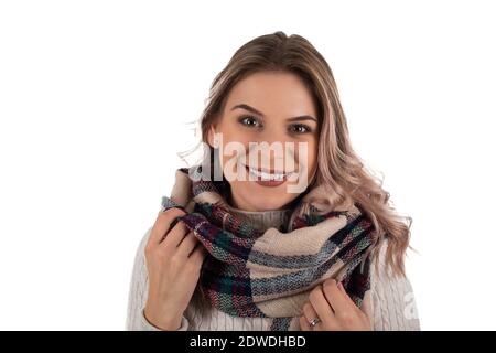 Portrait d'une femme gaie avec un chemisier tricoté et chaud foulard souriant à l'appareil photo sur un arrière-plan isolé Banque D'Images