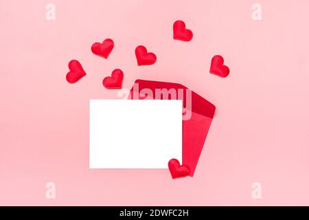 Enveloppe rouge, papier blanc écrit, coeurs sur fond rose Happy Valentine's Day concept, déclaration d'amour vue du dessus Flat Lay carte de vacances copie Banque D'Images