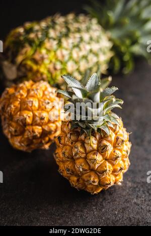 Ananas mûr. Mini ananas sur table noire. Banque D'Images