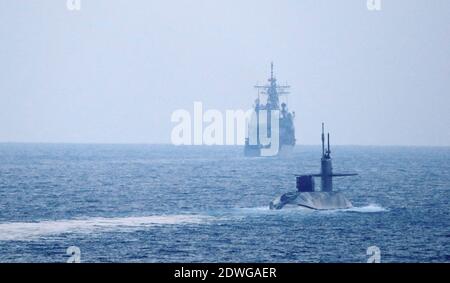 Photo du 21 décembre 2020 du croiseur à missiles guidés de classe Ticonderoga USS Port Royal (CG 73) et du croiseur à missiles guidés USS Philippine Sea (CG 58), non montré, escorte le sous-marin à missiles guidés de classe Ohio Georgia (SSGN 729) Sur le détroit d'OrmuzLa marine américaine semble envoyer un message à l'Iran sous la forme d'un sous-marin à missiles guidés équipé d'une puissance de feu énorme et éventuellement de troupes d'opérations spéciales. Le sous-marin de missiles guidés de classe Ohio USS Georgia a navigué dans le golfe Persique lundi. Pour la première fois en huit ans, la Marine a annoncé le presenc Banque D'Images