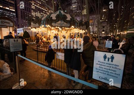 New York, États-Unis. 22 décembre 2020. Les gens font la queue pour un carrousel en plein air à New York, aux États-Unis, le 22 décembre 2020. Alors que la pandémie COVID-19 traverse le pays cette année, les gens ici doivent passer une période de vacances inhabituelle. Crédit : Wang Ying/Xinhua/Alay Live News Banque D'Images