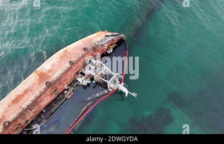 Un pétrolier en contrebas qui a frappé le rivage avec une tempête. Pollution côtière par le pétrole. Catastrophe écologique. Banque D'Images