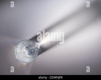 Verre d'eau vu d'en haut avec ombre de verre sur l'arrière-plan. Banque D'Images