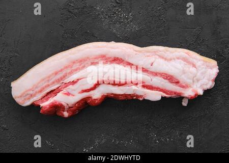 Tranche de poitrine de porc fraîche brute sur fond noir Banque D'Images
