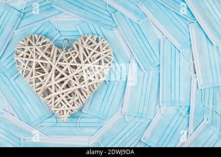 Image couleur horizontale avec une vue de face d'un coeur blanc sur un arrière-plan d'un visage bleu masques. Concept d'un jour de Saint-Valentin pendant le coronavirus ou le COV Banque D'Images