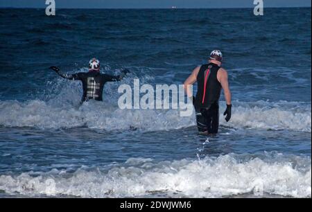 Portobello, Édimbourg, Écosse, Royaume-Uni. 23 décembre 2020. Les baigneurs d'eau froide de Hardy Sue et Jim brave une température de 1 degré avec des rafales de vent de 11 km/h et un ciel nuageux sombre pour leur plongeon matinal dans le Firth of Forth assez rugueux. Crédit : Arch White/Alamy Live News. Banque D'Images