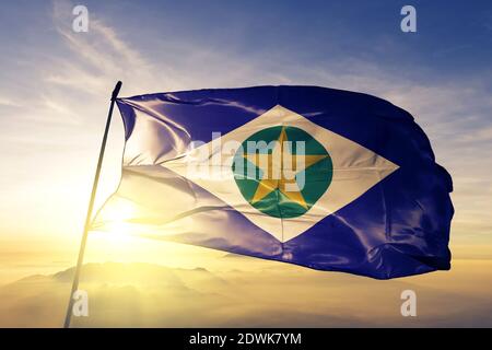 Le drapeau de l'État du Brésil de Mato Grosso agite sur le dessus brume de lever de soleil Banque D'Images