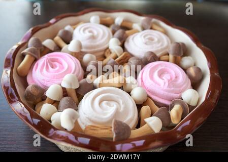 Plateau de Noël simple de fleurs rose et blanc de guimauve et biscuits bruns et blancs sous forme de champignons au chocolat bouchons Banque D'Images