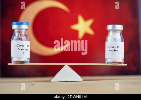 Concept de l'équilibre de deux vaccins sur des balances en bois, drapeau de la Turquie et vaccin Banque D'Images