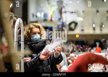 CLUJ-NAPOCA, ROUMANIE - 22 DÉCEMBRE 2020: Personnes portant un masque sur les lumières de Noël de rue Banque D'Images