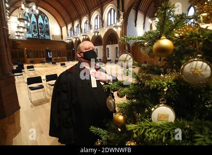 Le très Rév Dr Derek Browning ancien modérateur de l'Assemblée générale de l'Église d'Écosse avec l'arbre de Noël à l'intérieur de l'église paroissiale de Morningside, Édimbourg comme il fait la préparation pour les fidèles avant le service de jour de Noël. Banque D'Images