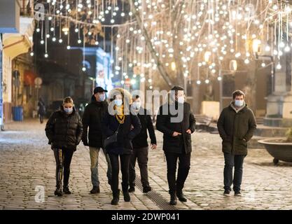 CLUJ-NAPOCA, ROUMANIE - 22 DÉCEMBRE 2020: Personnes portant un masque sur les lumières de Noël de rue Banque D'Images