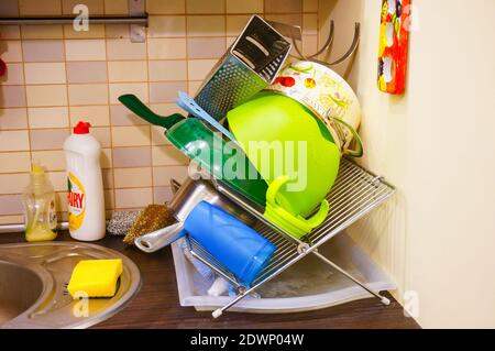 POZNAN, POLOGNE - 05 mars 2016 : pile de plats nettoyés de différentes marques sur une grille de séchage dans une cuisine Banque D'Images