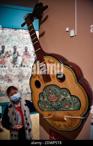 Haikou, province chinoise de Hainan. 23 décembre 2020. Les gens visitent une exposition au Musée Hainan à Haikou, dans la province de Hainan, au sud de la Chine, le 23 décembre 2020. L'exposition présente plus de 100 œuvres d'art des grottes de Dunhuang dans la province de Gansu, dans le nord-ouest de la Chine. Credit: Guo Cheng/Xinhua/Alamy Live News Banque D'Images