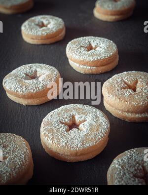 n beaucoup de biscuits remplis de confiture disposés sur un plateau noir rustique Banque D'Images