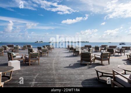 Plate-forme en bois donnant sur l'océan avec tables et canapés, restaurant dans un complexe de luxe, paradis tropical, Maldives. Banque D'Images