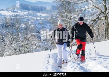 Couple senior marchant dans la nature avec des raquettes Banque D'Images