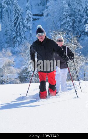 Couple senior marchant dans la nature avec des raquettes Banque D'Images