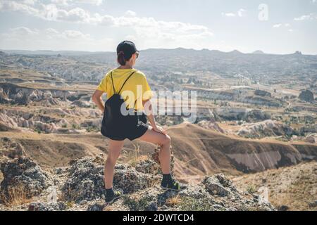 Vue arrière de la femme touriste debout sur la colline à Cappadoce, Turquie Banque D'Images