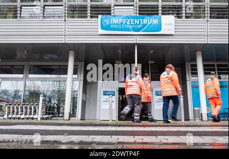 Greven, Allemagne. 23 décembre 2020. Les aides de la Croix-Rouge allemande marchent le long de la porte d'entrée du centre de vaccination du district de Steinfurt à l'aéroport de Münster-Osnabrück. Un essai a débuté à l'aéroport du centre de vaccination avec environ 50 personnes de test de THW, DLRG, Malteser, DRK Kreisverband ST et DRK Kreisverband TE. Credit: Guido Kirchner/dpa/Alay Live News Banque D'Images