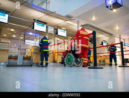 Greven, Allemagne. 23 décembre 2020. Des assistants de l'Agence fédérale allemande de secours technique (THW) et de la Société allemande de sauvetage (DLRG) se tiennent au bureau d'enregistrement du centre de vaccination du district de Steinfurt dans le terminal de l'aéroport de Münster-Osnabrück. Un essai au centre de vaccination a commencé à l'aéroport avec environ 50 personnes de test de THW, DLRG, Malteser, DRK Kreisverband ST et DRK Kreisverband TE. Credit: Guido Kirchner/dpa/Alay Live News Banque D'Images