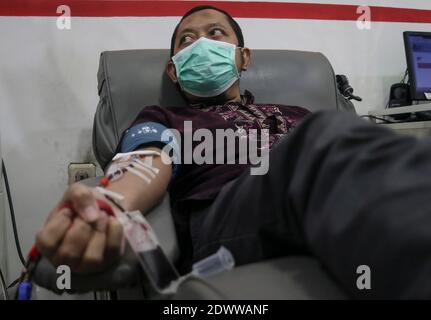 23 décembre 2020, Malang, est de Java, Indonésie: Imam Masruri (47 ans) qui s'est remis du coronavirus COVID-19 a donné du plasma sanguin au bureau de la Croix-Rouge à Malang, est de Java, Indonésie. Le ministère indonésien de la Santé a fait appel pour avoir récupéré le coronavirus COVID-19 pour donner leur plasma, car le nombre de cas de coronavirus en Indonésie a atteint plus de 685,639 le 23 décembre. Le plasma est recueilli à l'aide de la méthode de plasmaphérèse, au cours de laquelle le sang prélevé d'une veine est divisé en plasme et les éléments cellulaires restants du sang sont retransfusés à l' Banque D'Images