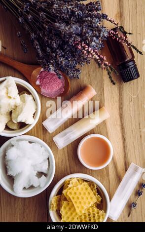 Ingrédients pour le baume à lèvres maison : beurre de karité, huile essentielle, poudre de couleur minérale, cire d'abeille, huile de coco. Mélange de baume à lèvres et de rouge à lèvres fait maison. Banque D'Images
