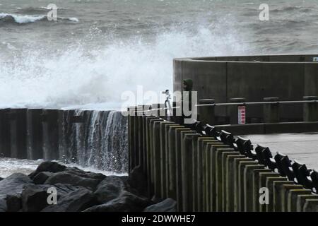 West Bay, Dorset, Royaume-Uni. 23 décembre 2020. Météo Royaume-Uni. Un photographe qui prend des photos des mers orageux alors qu'elles s'écrasont contre les défenses de la mer à West Bay à Dorset lors d'un après-midi de pluie et de vents violents. Crédit photo : Graham Hunt/Alamy Live News Banque D'Images