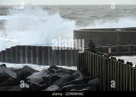 West Bay, Dorset, Royaume-Uni. 23 décembre 2020. Météo Royaume-Uni. Un photographe qui prend des photos des mers orageux alors qu'elles s'écrasont contre les défenses de la mer à West Bay à Dorset lors d'un après-midi de pluie et de vents violents. Crédit photo : Graham Hunt/Alamy Live News Banque D'Images