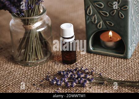 Lampe d'arôme avec une huile aromatique et une bougie brûlante avec un seau de lavande dans le verre, concept d'aromathérapie Banque D'Images