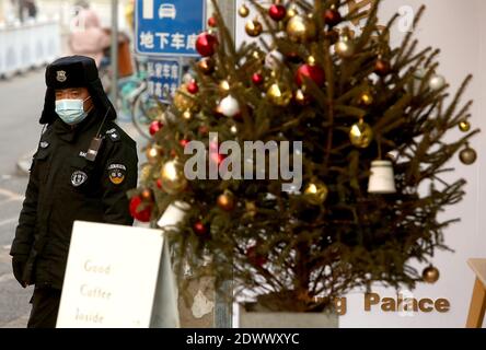 Pékin, Chine. 23 décembre 2020. Un policier surveille la circulation à côté d'un arbre de Noël placé à l'extérieur d'un café occidental à Beijing le mercredi 23 décembre 2020. Noël est devenu un événement majeur en Chine avec l'accent étant mis sur le shopping et les dîners avec la famille et les amis. Photo de Stephen Shaver/UPI crédit: UPI/Alay Live News Banque D'Images