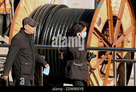 Pékin, Chine. 23 décembre 2020. La promenade chinoise passe devant un chantier de construction à Pékin le mercredi 23 décembre 2020. La croissance économique de la Chine semble se poursuivre en 2021, mais le boom des infrastructures du pays approche de son pic, disent les analystes. Photo de Stephen Shaver/UPI crédit: UPI/Alay Live News Banque D'Images