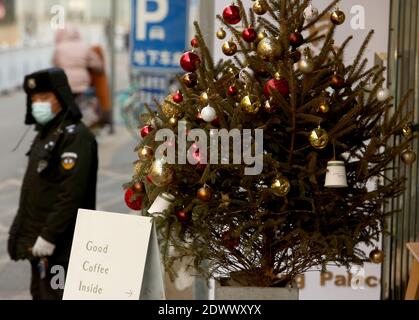 Pékin, Chine. 23 décembre 2020. Un policier surveille la circulation à côté d'un arbre de Noël placé à l'extérieur d'un café occidental à Beijing le mercredi 23 décembre 2020. Noël est devenu un événement majeur en Chine avec l'accent étant mis sur le shopping et les dîners avec la famille et les amis. Photo de Stephen Shaver/UPI crédit: UPI/Alay Live News Banque D'Images