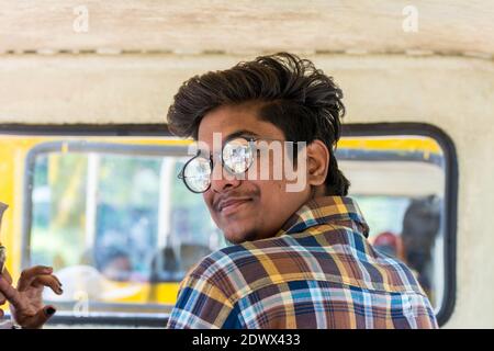 Portrait d'un jeune Indien portant des lunettes de soleil dans le mini train du parc zoologique de Nehru, Hyderabad, Inde Banque D'Images