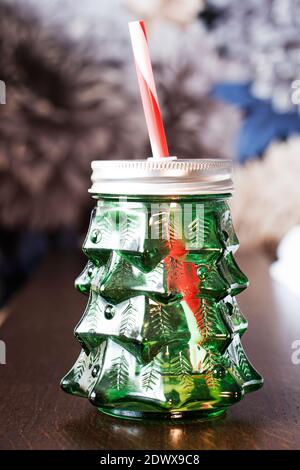 Vider le pot de maçon en verre de smoothies sous forme d'arbre de Noël avec des pailles sur table en bois et de couleur de fond. Tasse en verre pour jus, smoo de légumes Banque D'Images