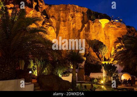 Des grottes sur une falaise de montagne s'illuminent la nuit sur l'île de Lanzarote, en Espagne. Attractions touristiques, concepts de destination de voyage Banque D'Images