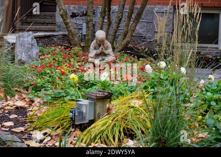 Une statue de Bouddha au milieu du jardin de cour avant à quartier résidentiel Banque D'Images