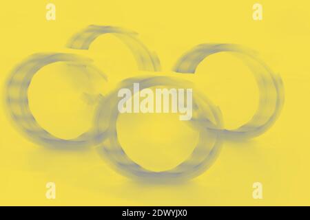 Quatre anneaux gris sur fond jaune, arrière-plan dynamique abstrait avec les couleurs de l'année 2021 Banque D'Images